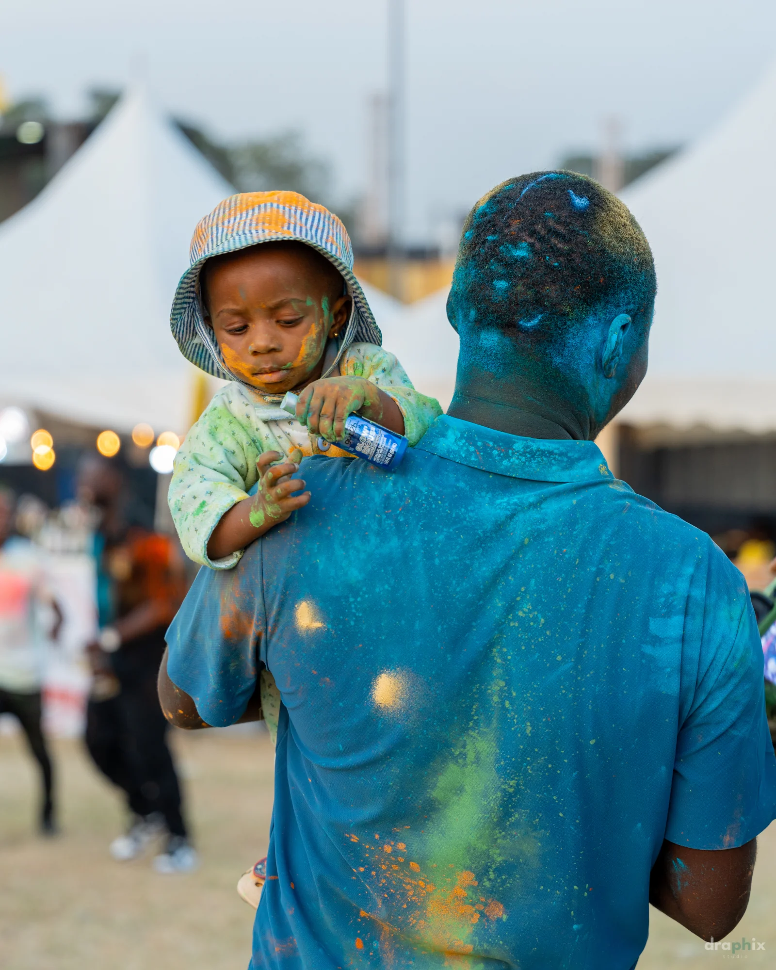 Parent carrying a child at the festival
