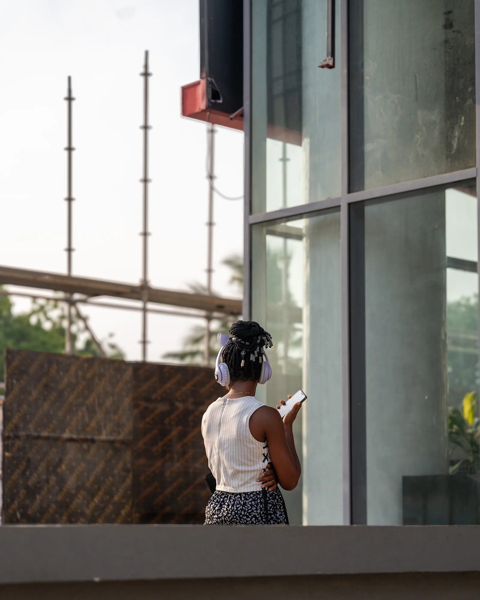 Woman with headphones by glass wall